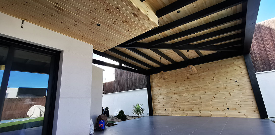 Interior-cubierta-porche-madera-adosado-a-dos-aguas-con-forrado-de-techo-y-pared